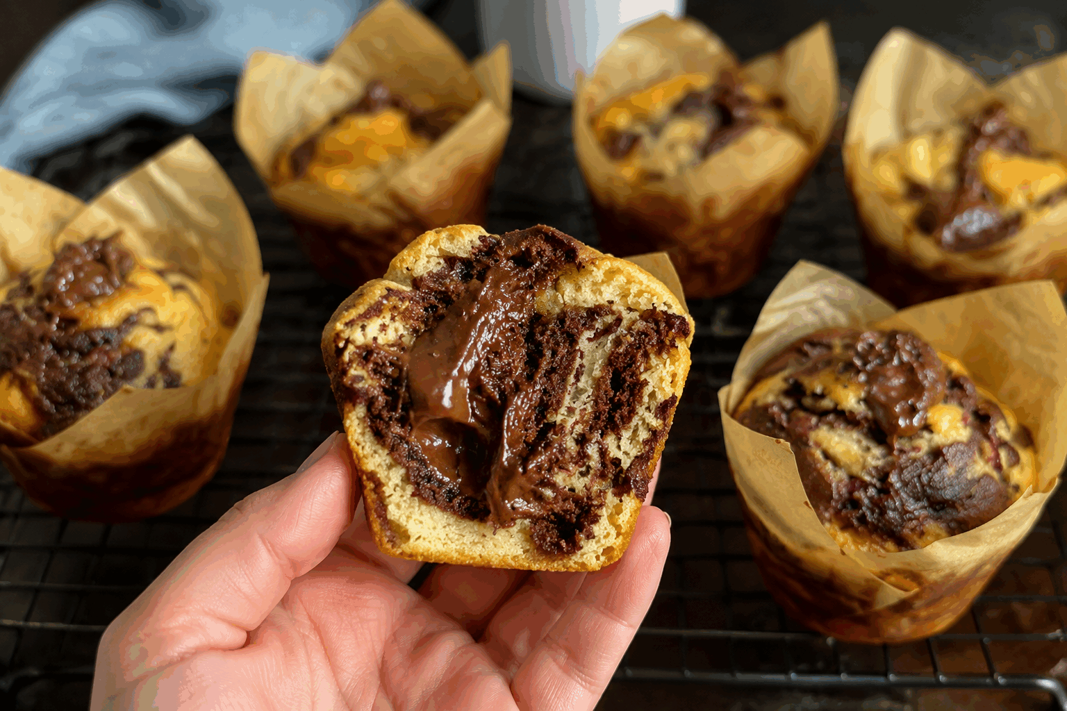 Ces muffins marbrés fourrés au chocolat fondent en bouche en moins de 10 minutes👌 Description Ces muffins marbrés allient moelleux et gourmandise grâce à leur pâte bicolore délicatement alternée et leur cœur fondant au chocolat. Faciles et rapides à préparer, ils sont parfaits pour une collation ou un goûter express qui ravira petits et grands. Informations Temps de préparation : 8 minutes Temps de cuisson : 15 minutes Nombre de portions : 8 muffins Difficulté : Facile Ingrédients Pour la pâte 200 g de farine 100 g de sucre 100 ml de lait 80 ml d’huile végétale neutre 2 œufs 1 sachet de levure chimique (environ 10 g) 1 cuillère à soupe de cacao en poudre non sucré 1 pincée de sel Pour la garniture 80 g de chocolat noir pâtissier Préparation Préchauffe le four à 180°C (chaleur statique). Dans un grand saladier, bats les œufs avec le sucre jusqu’à ce que le mélange blanchisse. Ajoute l’huile puis le lait en continuant de mélanger. Incorpore la farine, la levure et la pincée de sel. Mélange juste assez pour obtenir une pâte homogène. Sépare la pâte en deux parts à peu près égales. Dans l’une, ajoute le cacao en poudre et mélange bien pour obtenir la pâte au chocolat. Prépare un moule à muffins avec des caissettes en papier ou en silicone. Dépose une cuillère à soupe de pâte nature dans chaque moule, puis une petite portion de chocolat coupé en morceaux (environ 10 g). Recouvre avec une cuillère de pâte au chocolat, puis à nouveau un peu de pâte nature pour finir. Avec la pointe d’un couteau ou un cure-dent, trace doucement des spirales pour créer un effet marbré en veillant à ne pas trop mélanger. Enfourne pour 15 minutes. Vérifie la cuisson en piquant avec un cure-dent : il doit ressortir propre mais humide près du cœur chocolaté. Laisse refroidir 5 minutes avant de démouler. Déguste tiède pour un effet fondant optimal. Astuces Pour obtenir un cœur encore plus fondant, place un carré de chocolat au lait au centre avant cuisson. Ne mélange pas trop la pâte après ajout de la farine pour éviter que les muffins deviennent durs. Si tu n’as pas de cacao pur, remplace-le par de la poudre de Nesquik pour un goût plus doux. Conserve les muffins dans une boîte hermétique à température ambiante jusqu’à 2 jours pour garder leur moelleux. Service Servez ces muffins tièdes avec une tasse de thé ou de café pour un goûter rapide et gourmand. Ils accompagnent aussi parfaitement un petit-déjeuner express ou une pause sucrée en milieu d’après-midi.